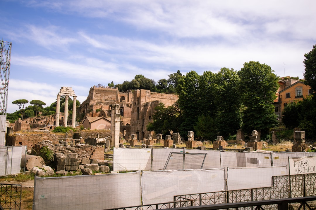 a stone building with columns and a fence around it