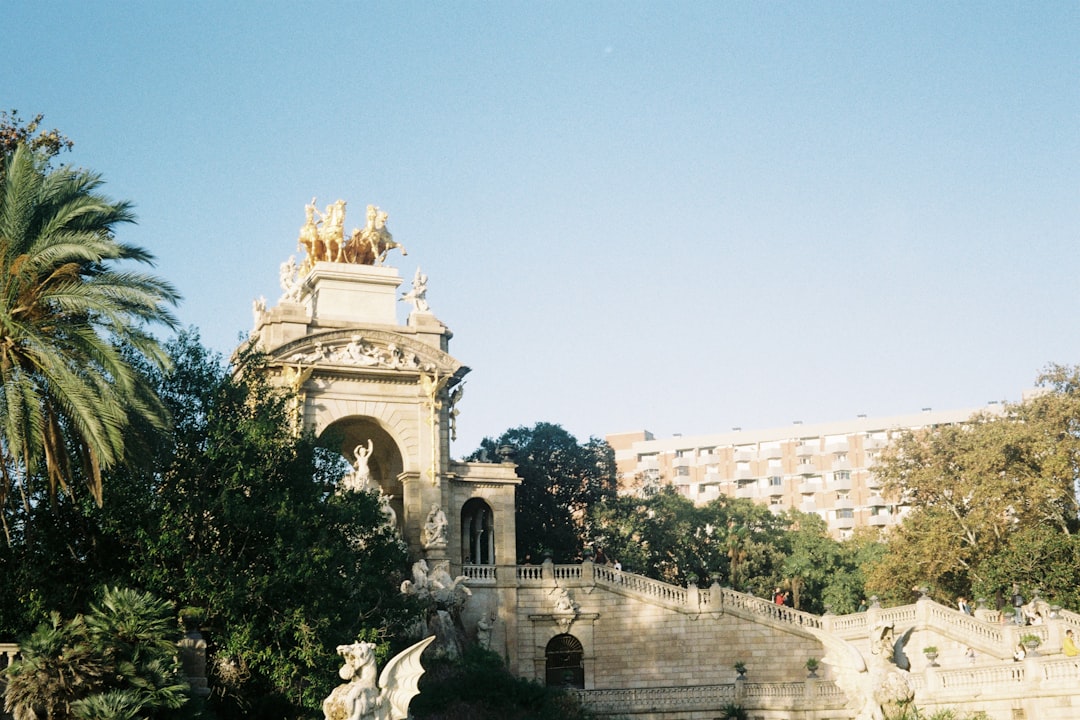 A fountain in a park with a clock tower in the background