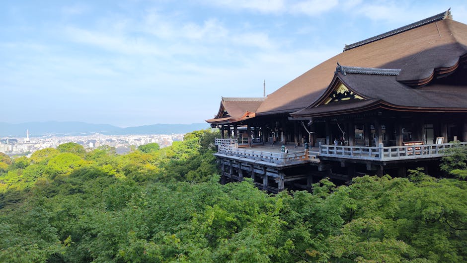 Scenic view of Kiyomizu-dera Temple surrounded by lush greenery in Kyoto, Japan.