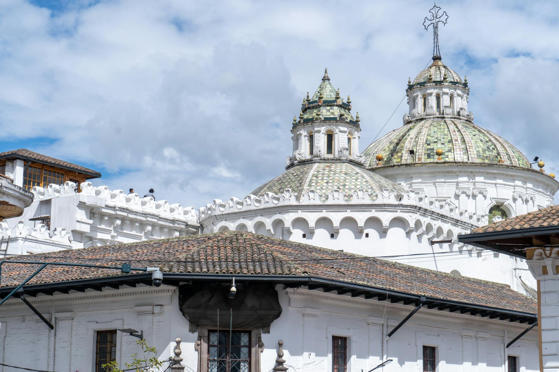 Beautiful view of historic church domes under a bright blue sky in Quito, Ecuador.