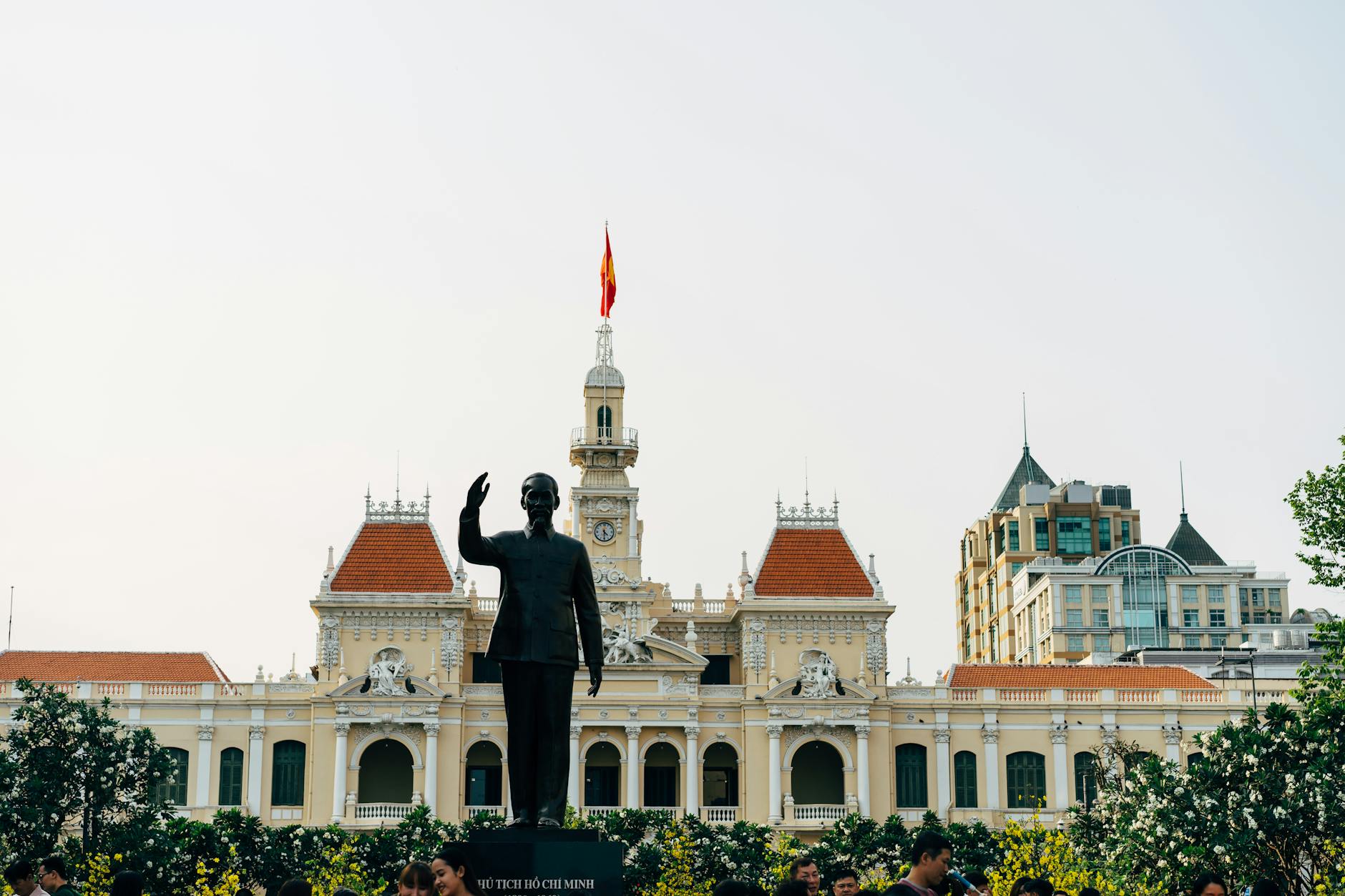 A silhouette of Ho Chi Minh statue with the French colonial City Hall in Ho Chi Minh City.
