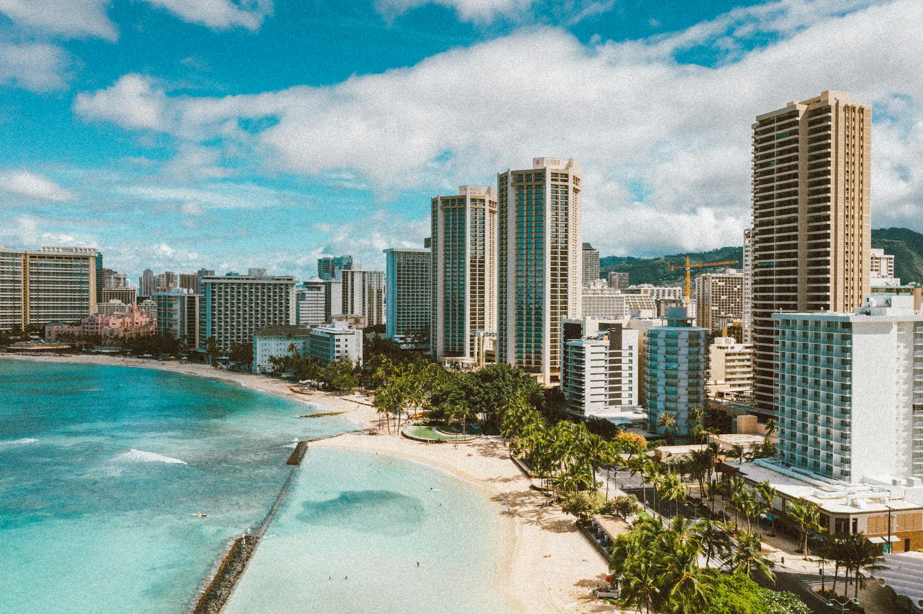 A stunning view of Honolulu's beachfront skyline with palm trees and blue ocean.