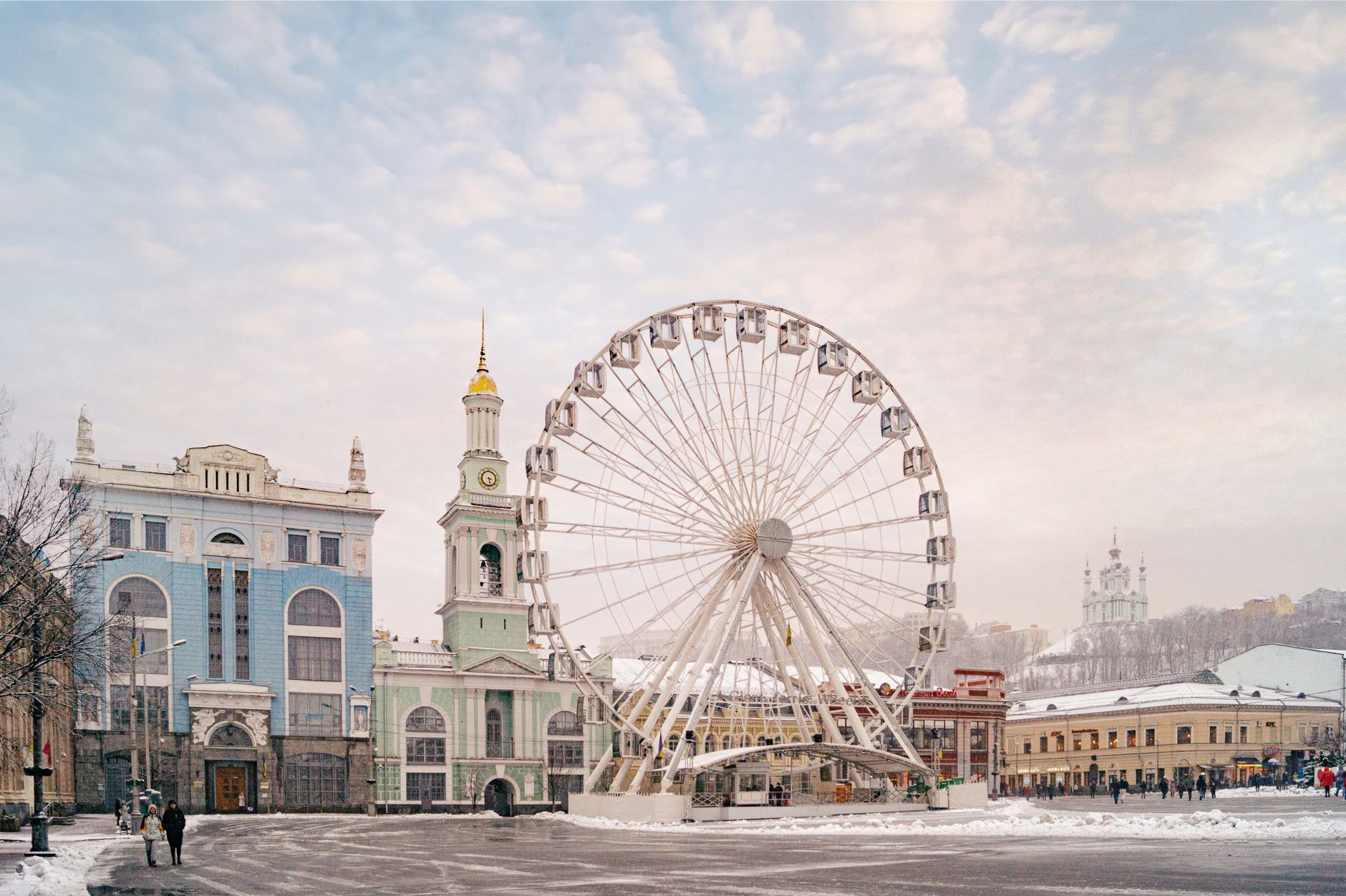 Captivating winter cityscape of the Podil Ferris Wheel and historic architecture in Kyiv, Ukraine.