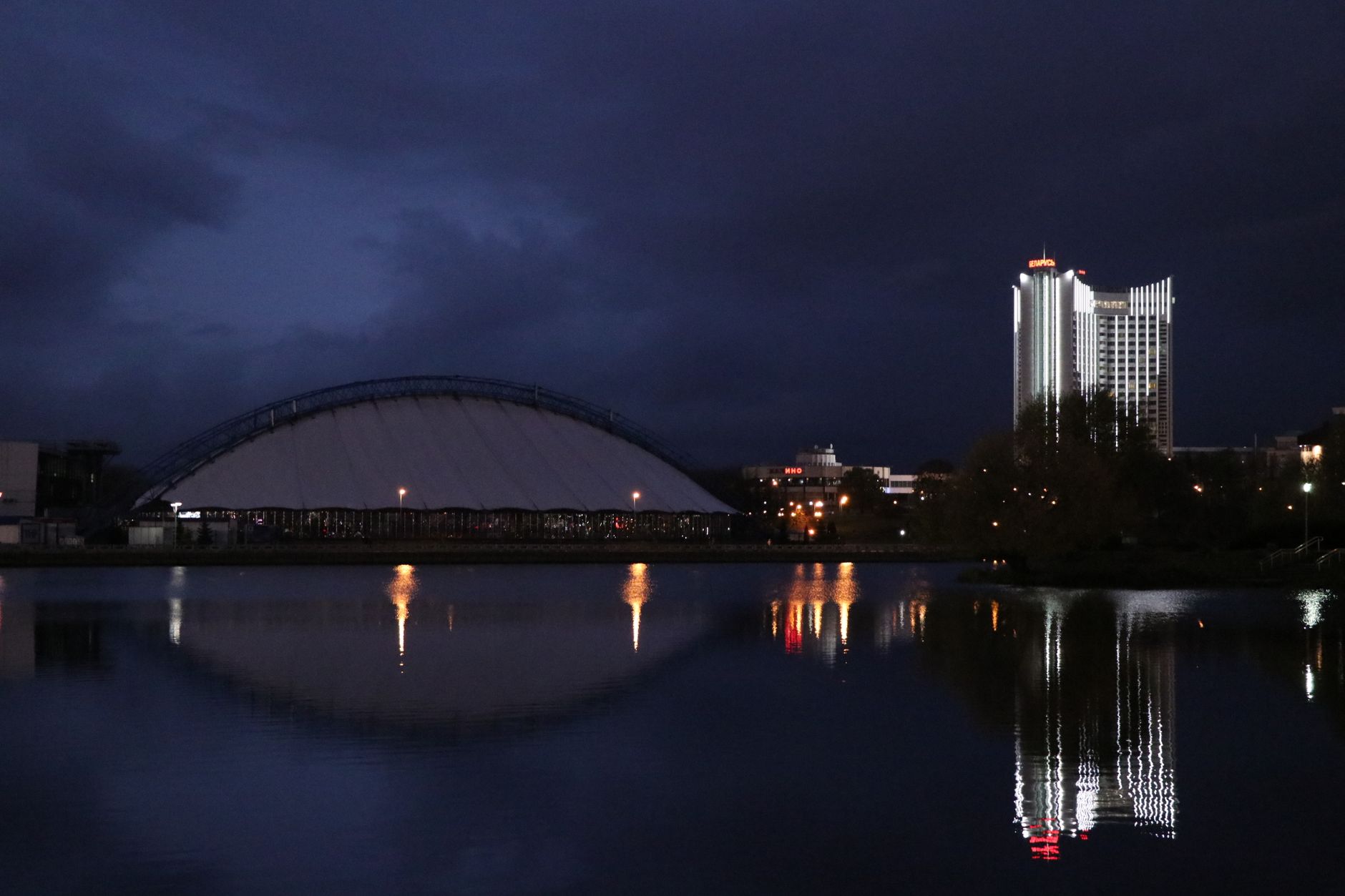 Illuminated buildings reflecting in the river at night in Minsk, Belarus.