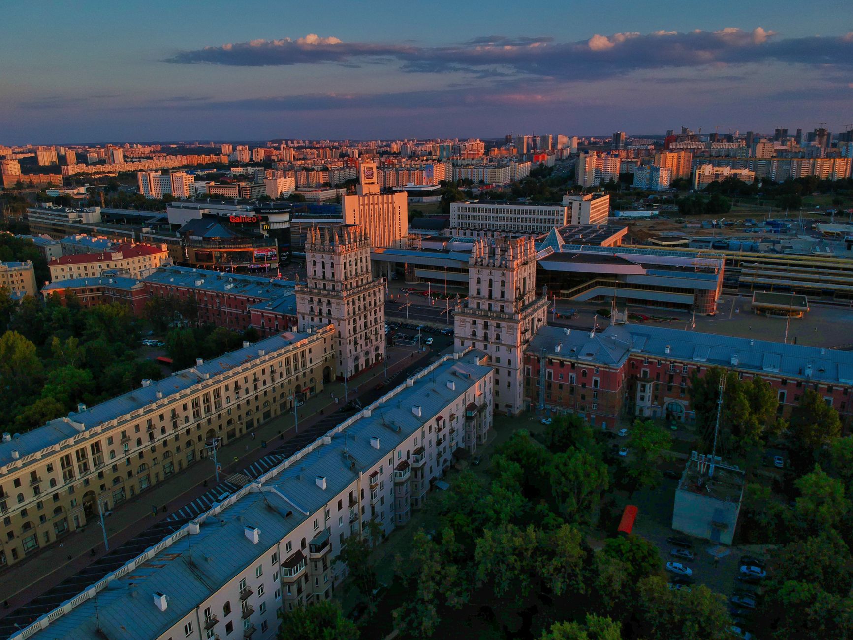Aerial view of Minsk, Belarus cityscape with iconic architecture under a vibrant sunset sky.