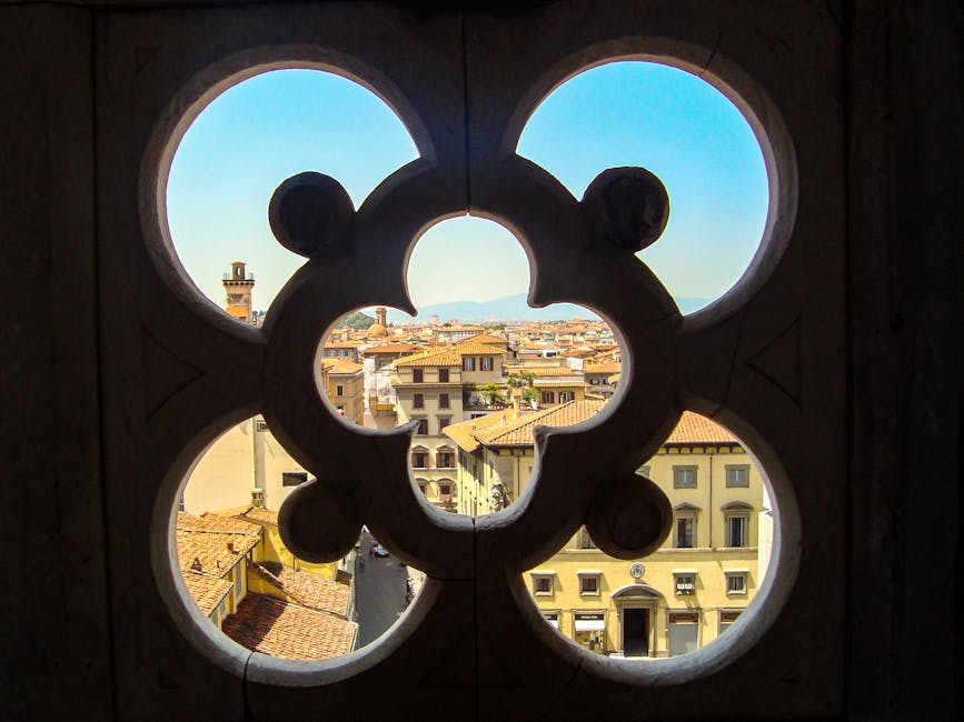 A picturesque view of Florence, Italy, seen through a historic window frame, highlighting the city's architecture.