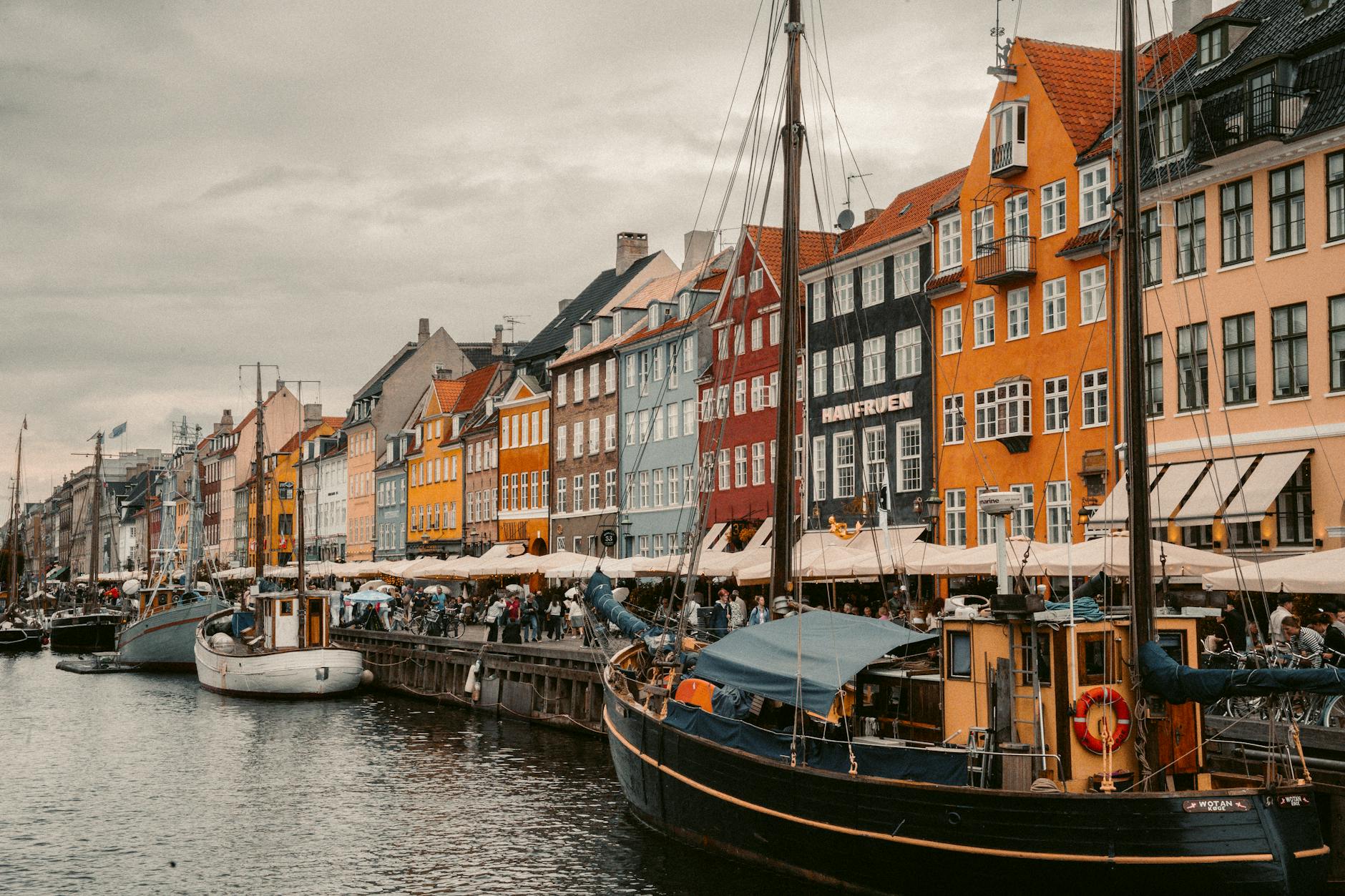 Vibrant Nyhavn canal view with historic buildings and boats in Copenhagen, Denmark.