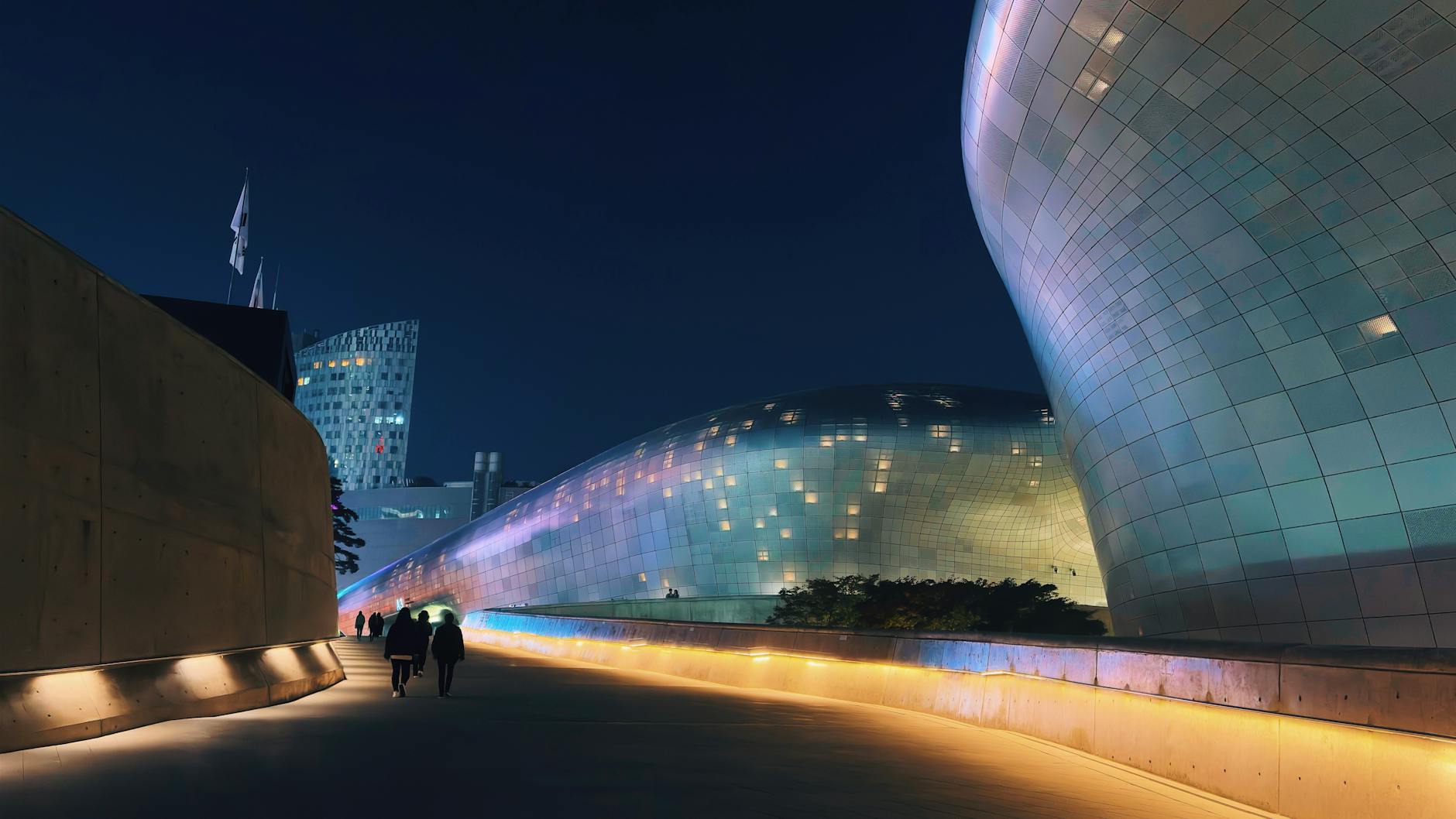 Vibrant night view of Dongdaemun Design Plaza's futuristic architecture in Seoul, South Korea.