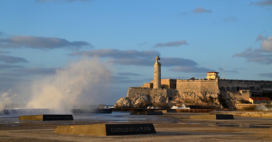 Dramatic waves crash near Morro Castle and lighthouse in La Habana, Cuba.