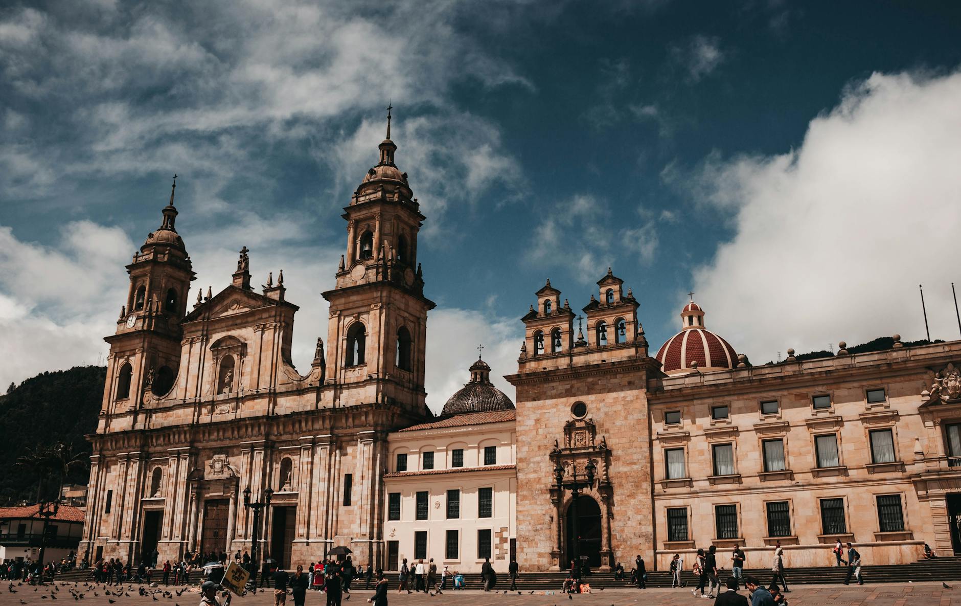 Stunning view of the Cathedral Primada in Bogotá's public square, surrounded by people and rich architecture.