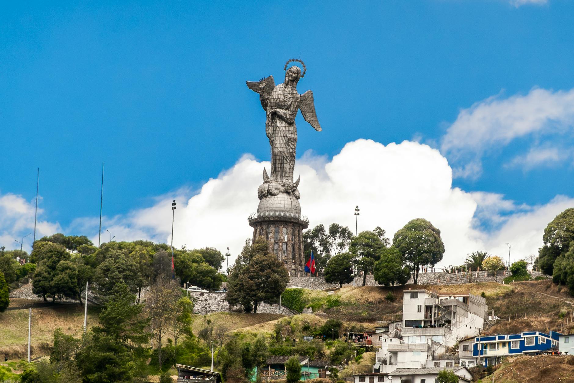 The majestic Panecillo angel statue stands over Quito, Ecuador with a clear blue sky backdrop.