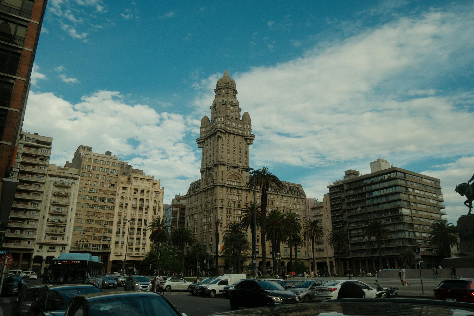 Street view of Salvo Palace in Montevideo with blue sky and city traffic.