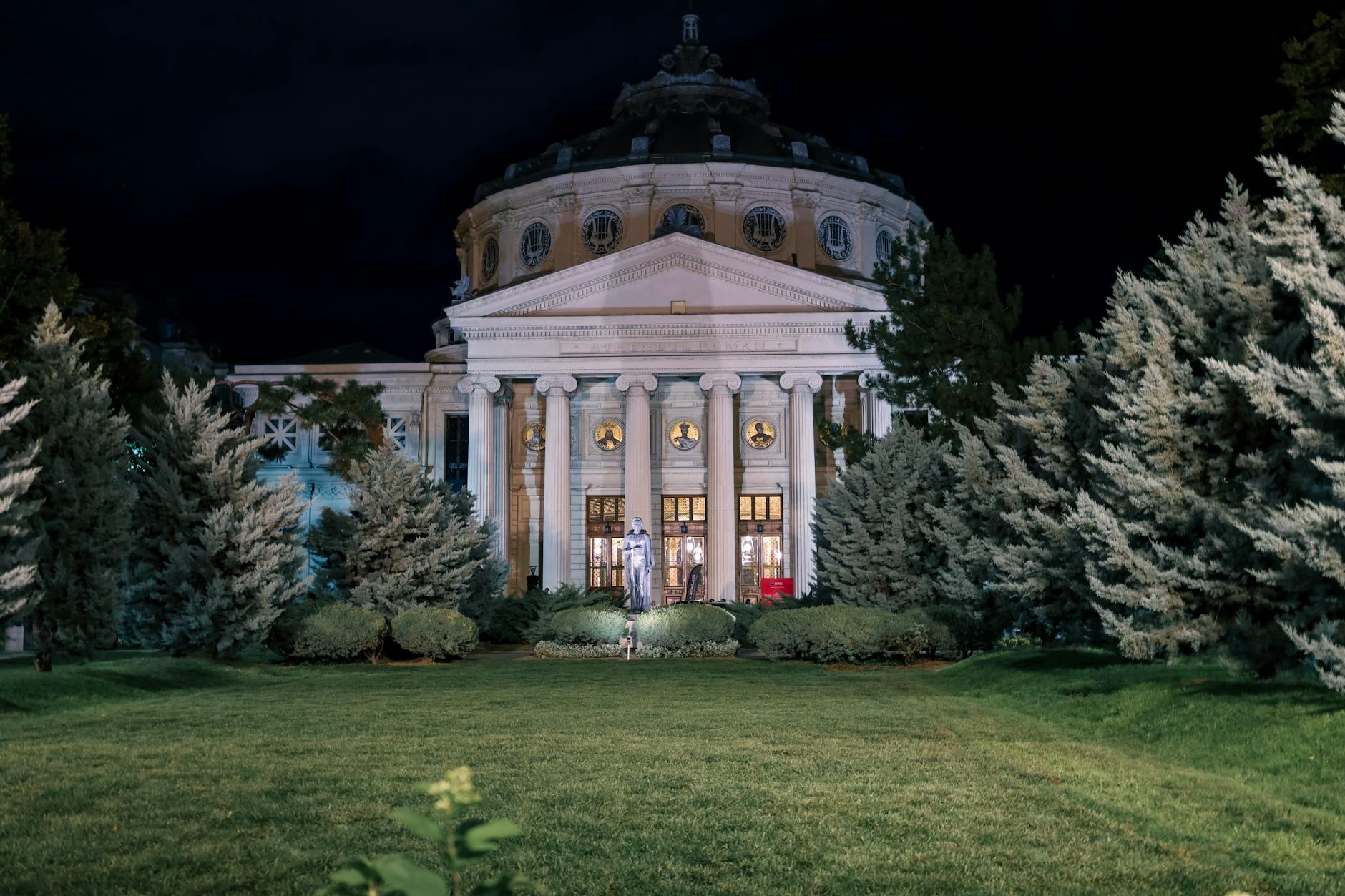 The Romanian Athenaeum illuminated at night, showcasing grand architecture in Bucharest, Romania.