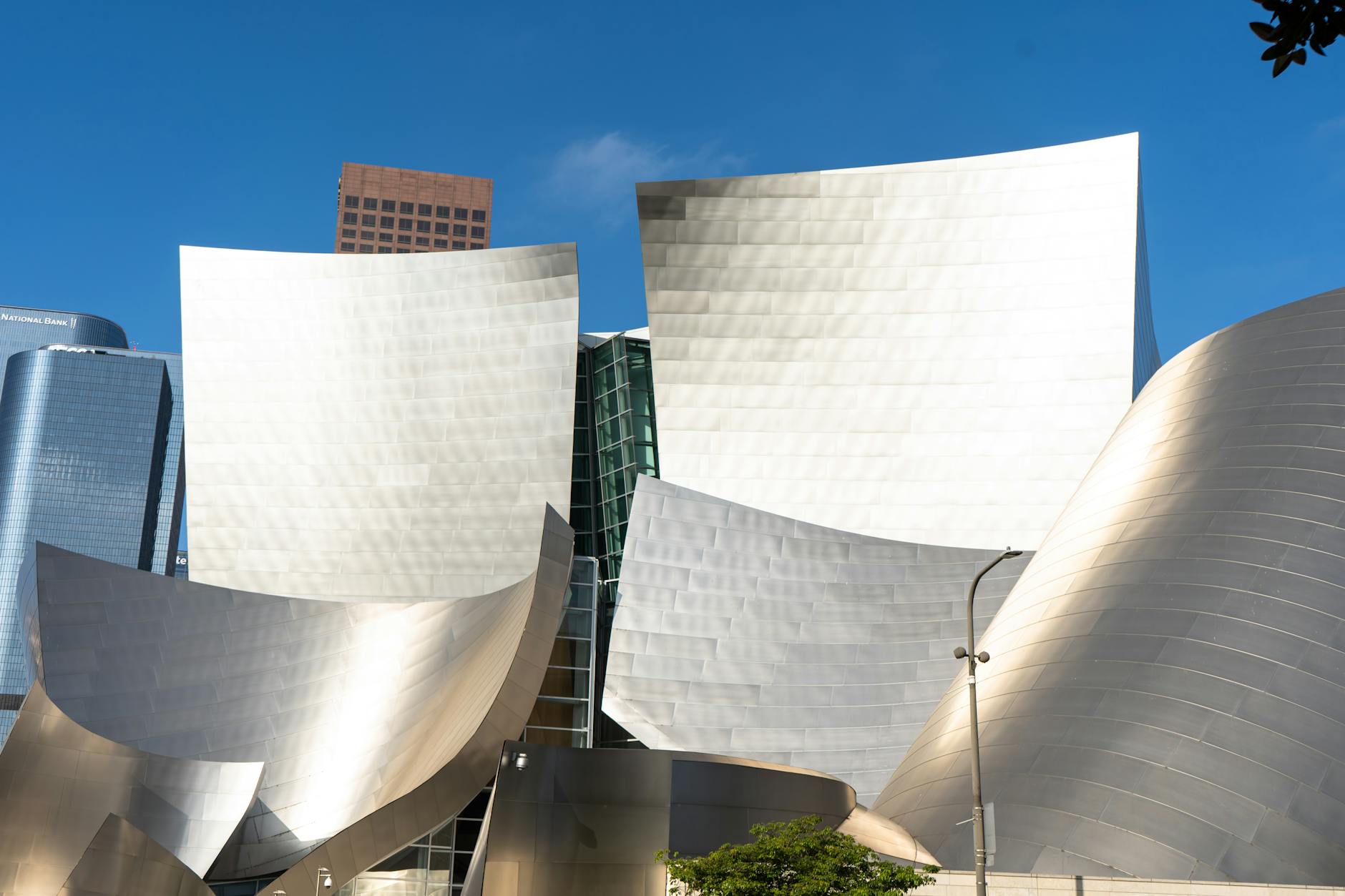 Stunning view of the iconic Walt Disney Concert Hall's stainless steel facade against a clear blue sky.