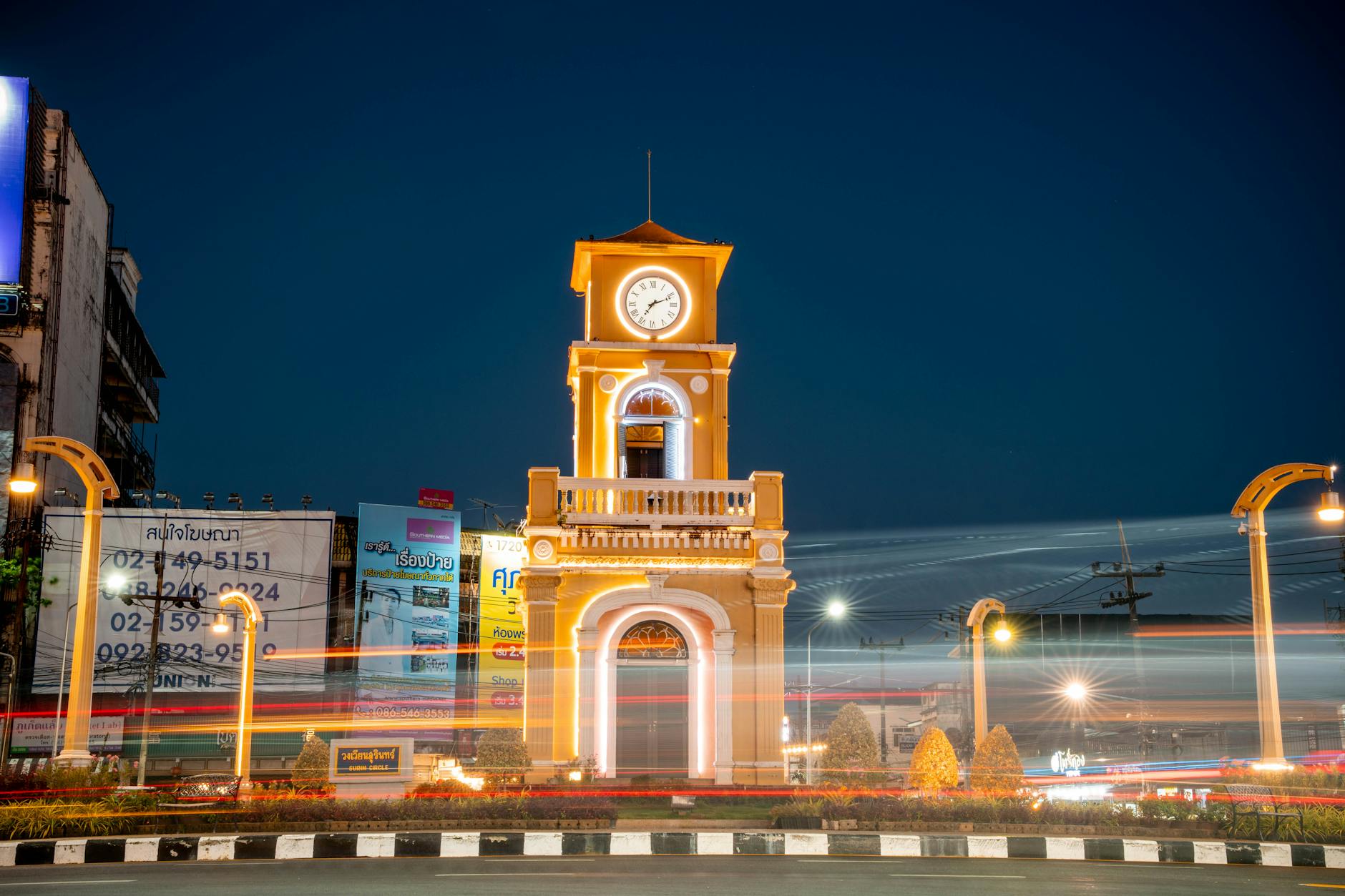 Night view of the illuminated Phuket Clock Tower with vibrant light trails