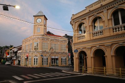 Charming colonial buildings with vintage architecture in Phuket Town during dusk, featuring a clock tower.