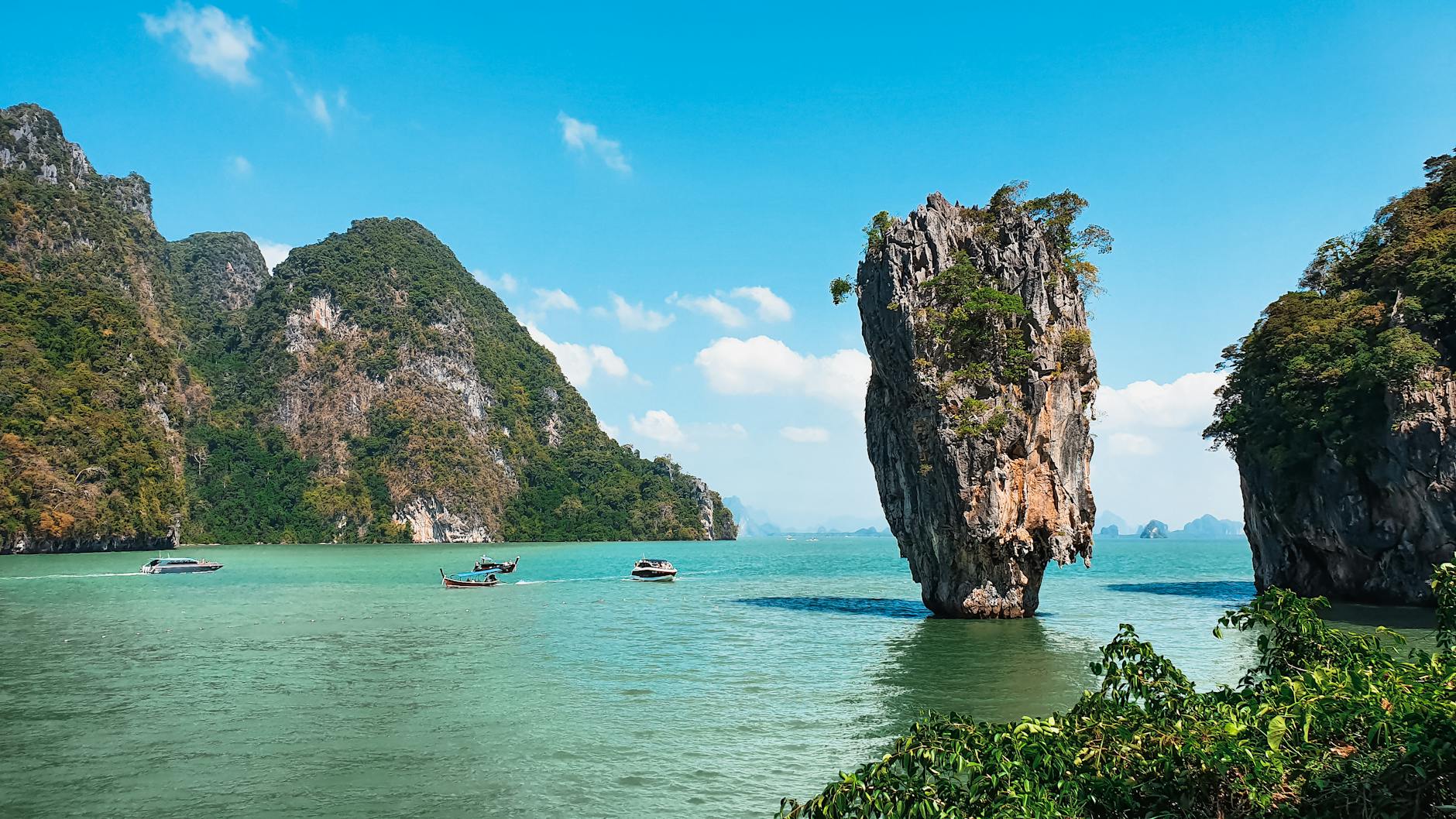 Scenic view of James Bond Island in Thailand with boats and turquoise water.