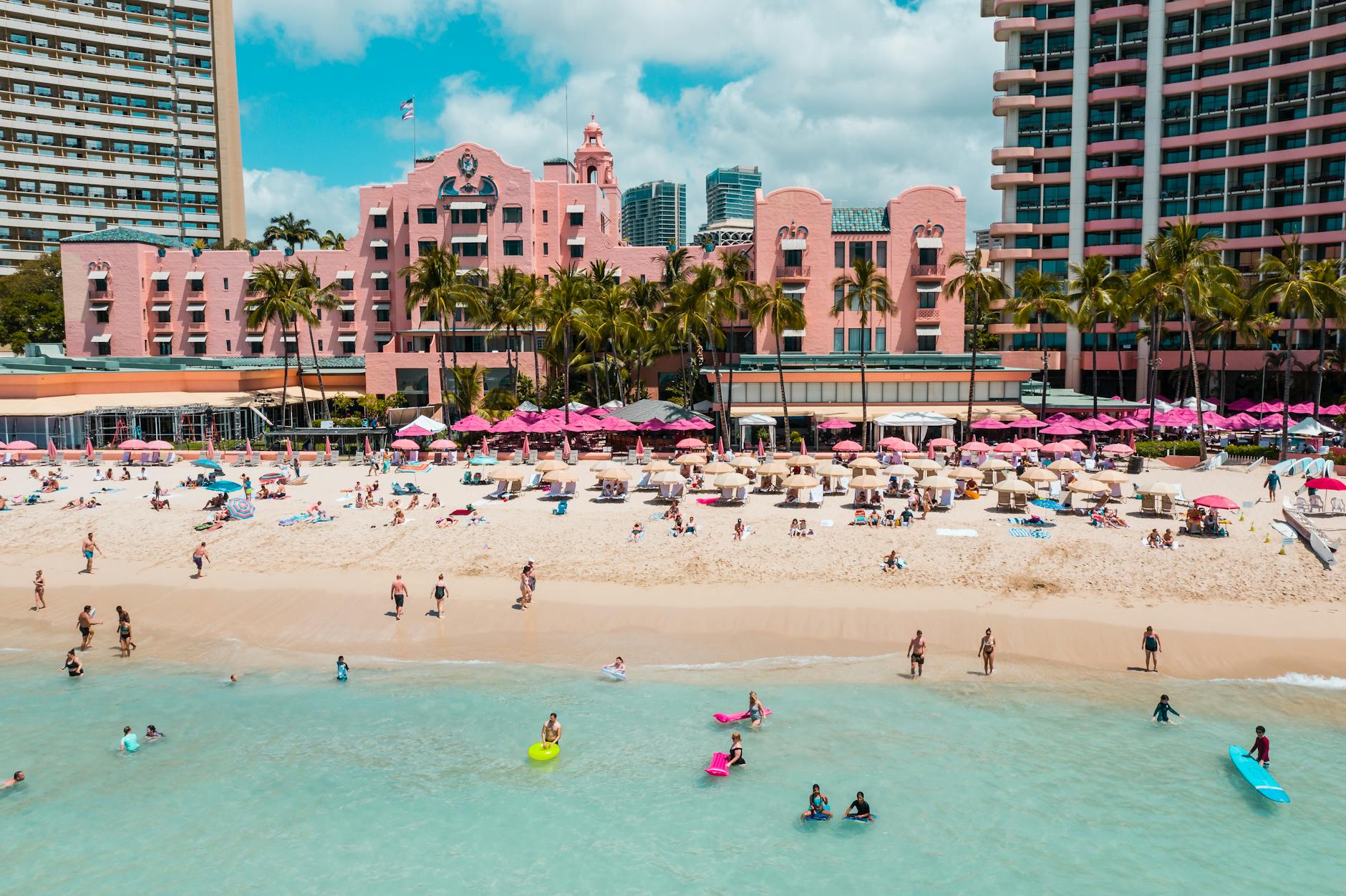 Lively Waikiki Beach in Honolulu, featuring vibrant hotels and tourists enjoying a sunny day.
