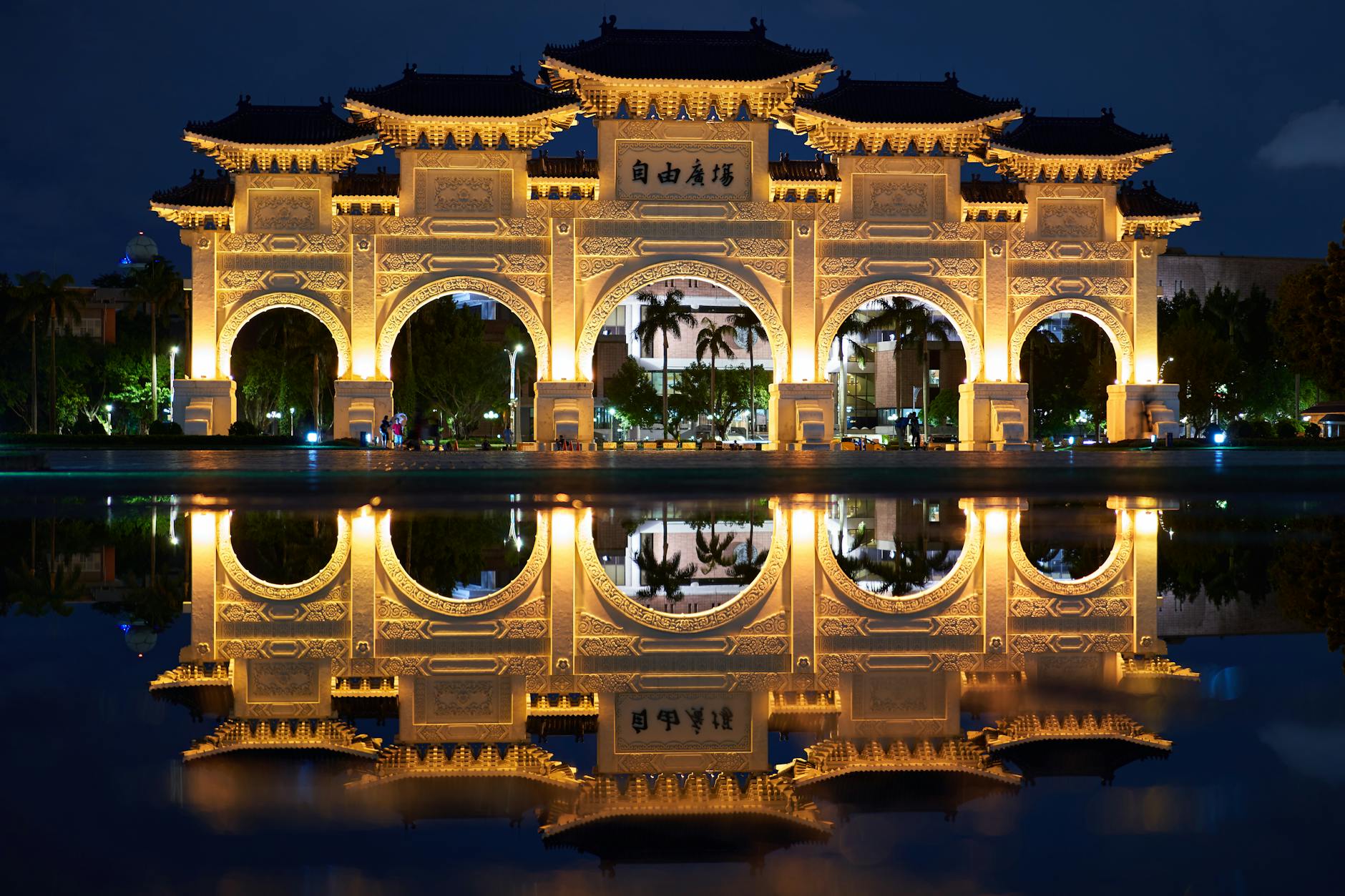 Beautifully lit gateway reflecting on water in Taipei, Taiwan at night.