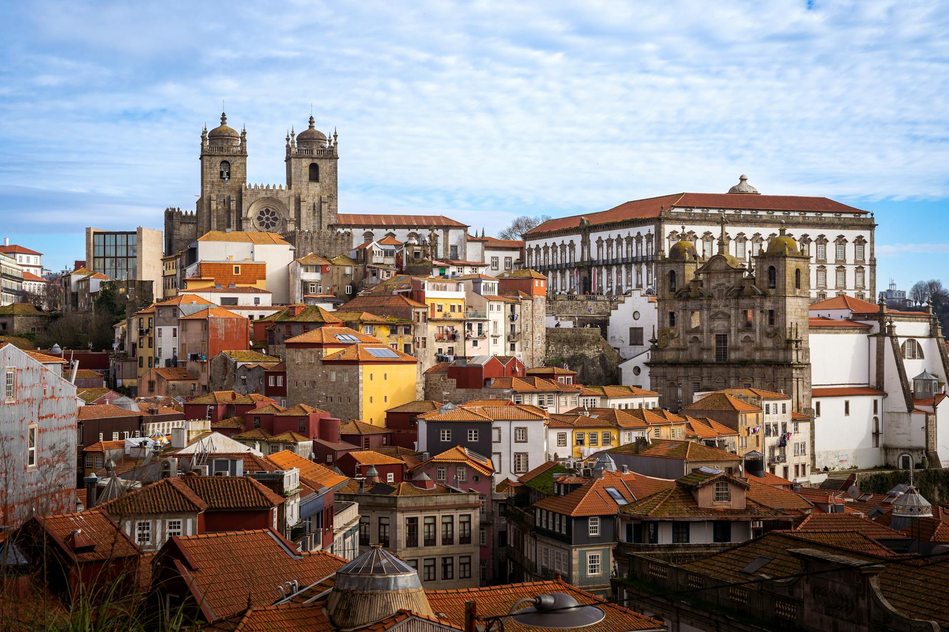 Scenic aerial view of Porto's historic architecture with iconic landmarks under a blue sky.