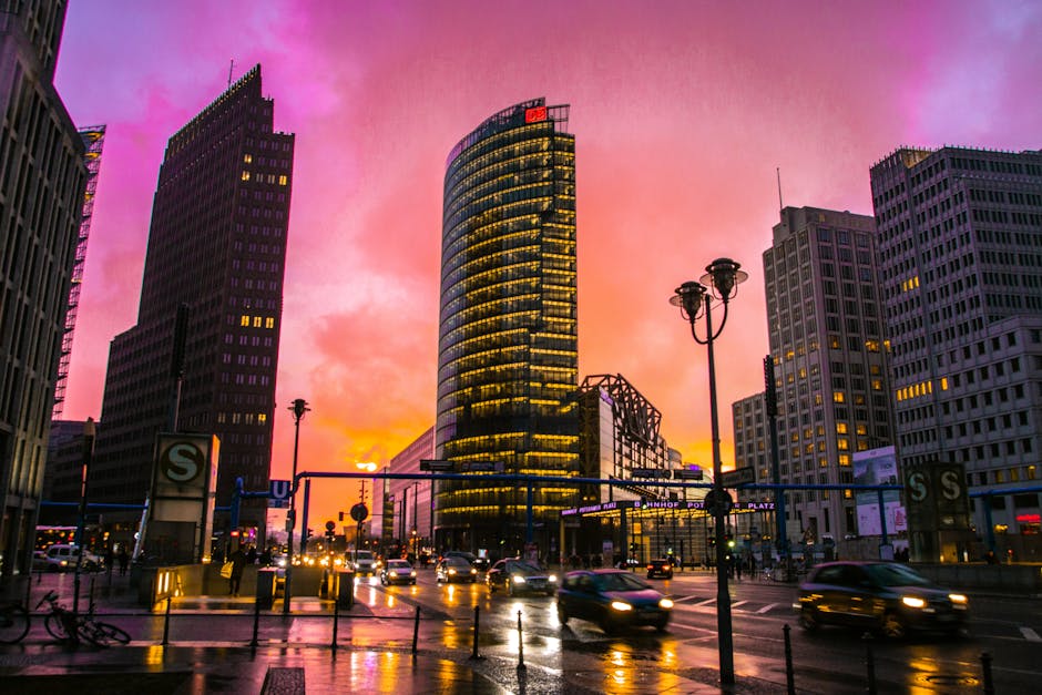 Captivating view of Berlin's skyline at sunset with illuminated skyscrapers and bustling street.