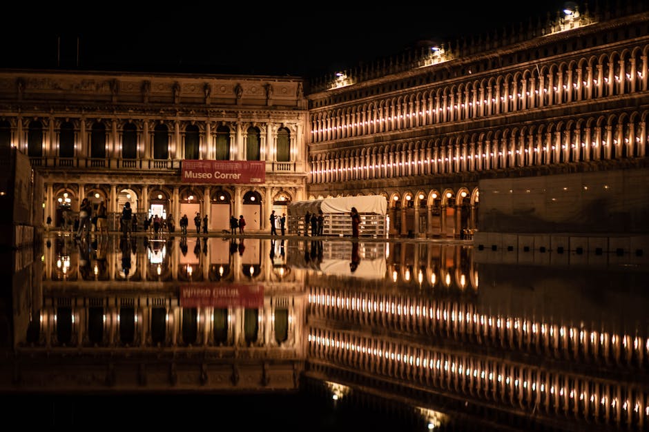 Stunning night view of the illuminated facade and reflection in St. Mark's Square, Venice.