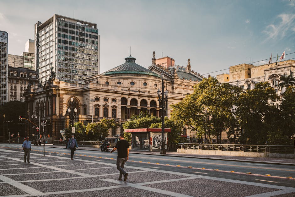 Theatro Municipal in São Paulo, Brazil, captures urban life with people strolling in a lively square.