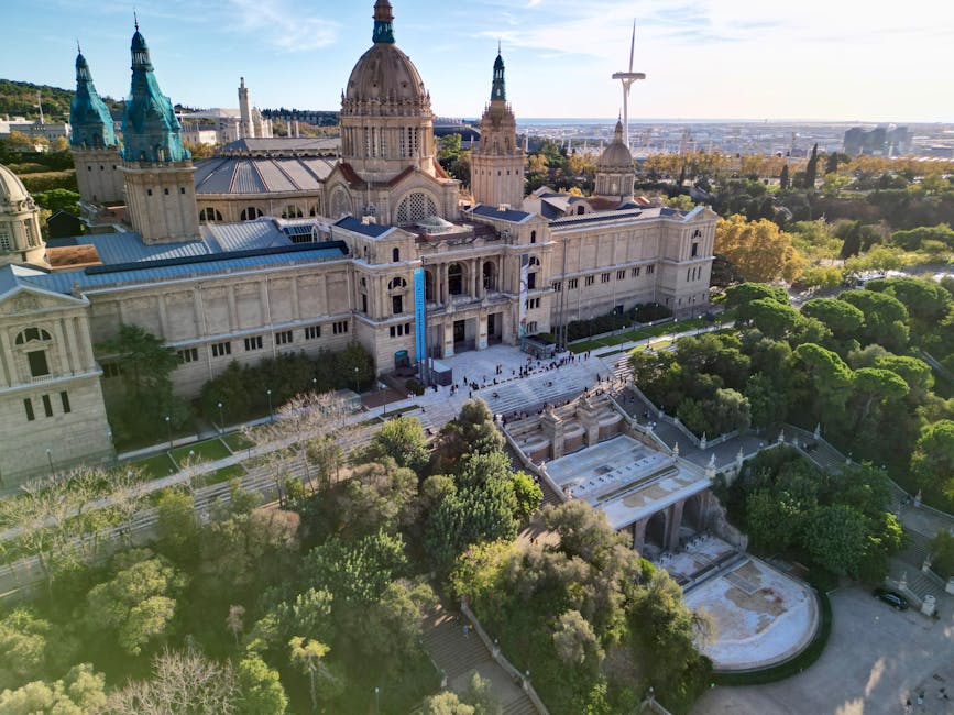 Aerial photo of the National Palace in Montjuïc, Barcelona, surrounded by lush greenery.
