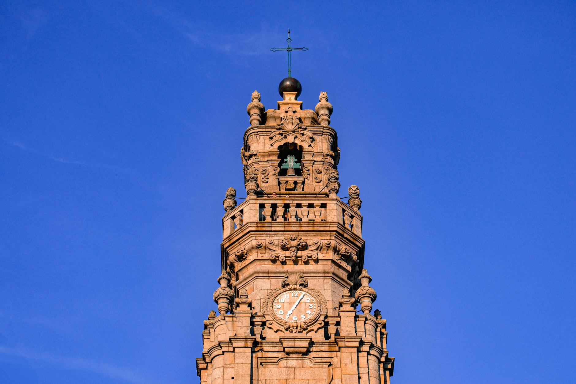 Stunning view of Clérigos Tower, a historic landmark in Porto, Portugal, under a vivid blue sky.
