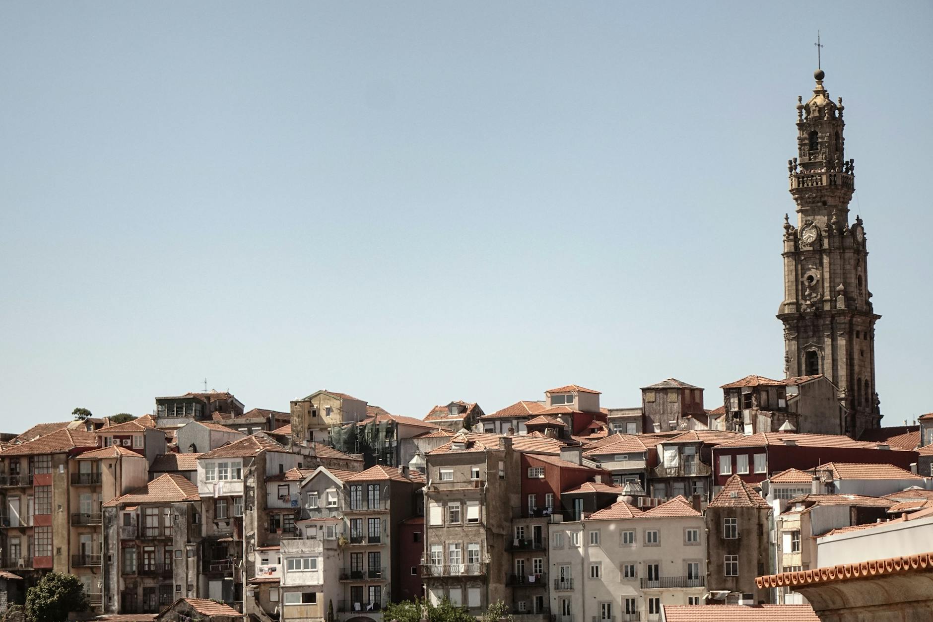 Scenic view of Porto's historic buildings and Clerigos Tower under a clear sky.