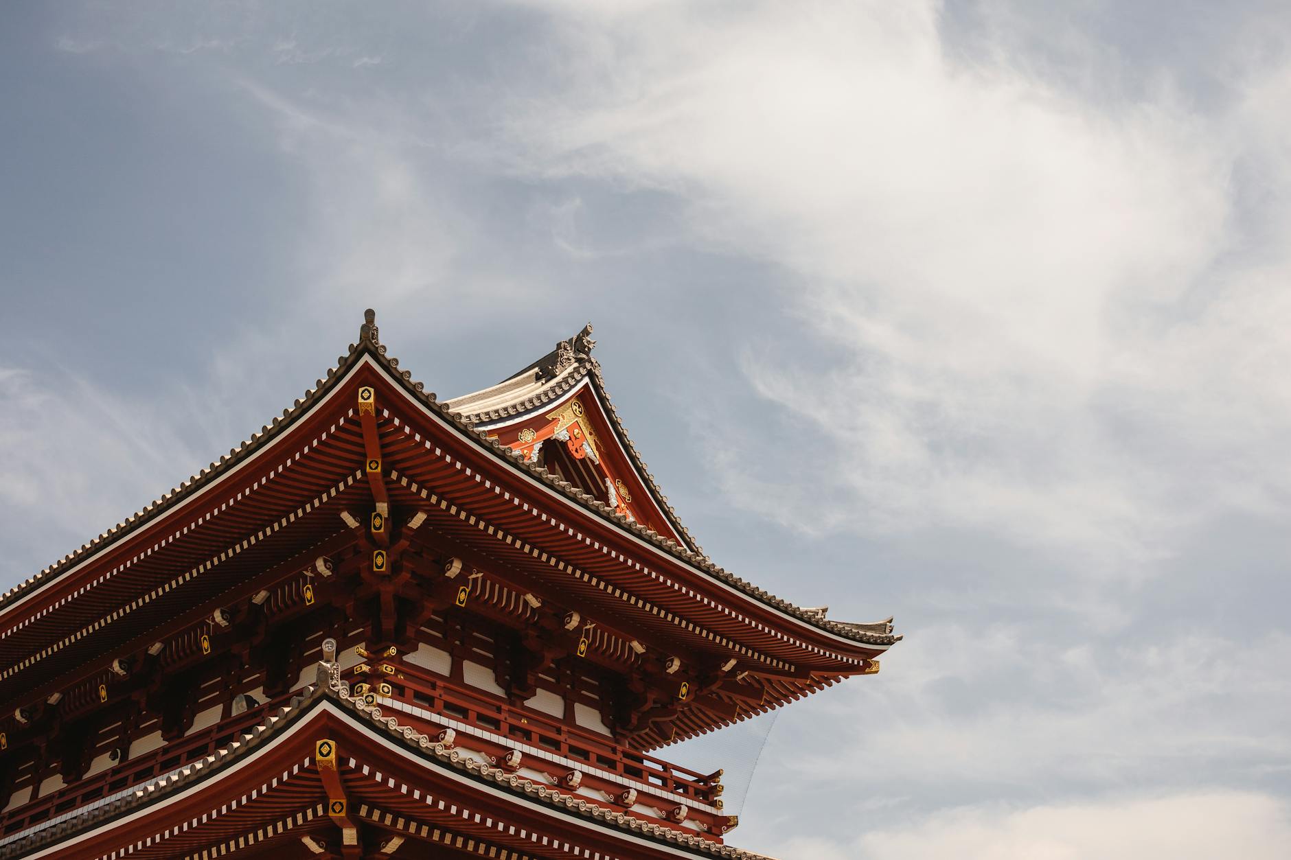 Low angle view of Senso-ji Temple roof in Tokyo, Japan against the clouds.