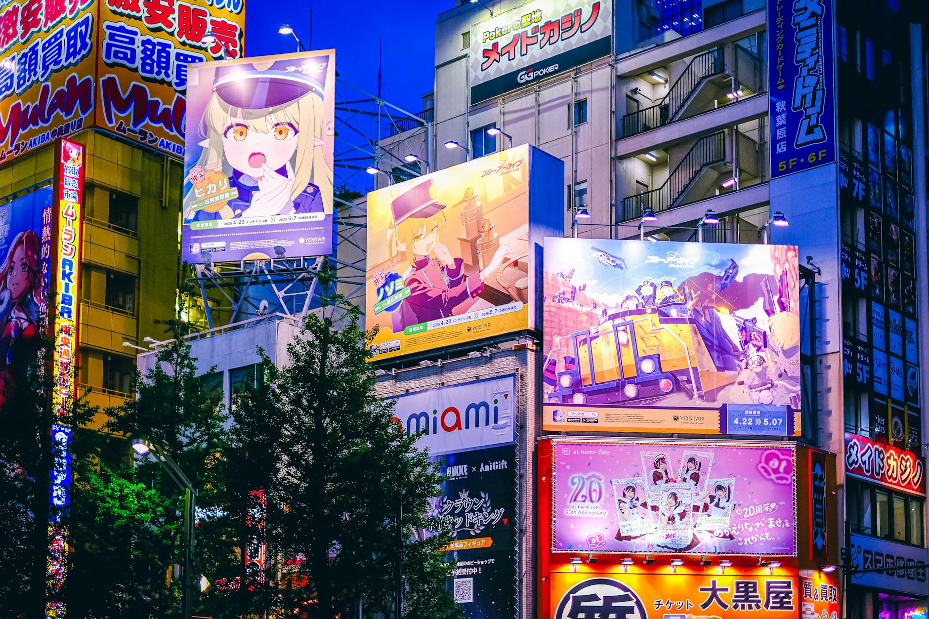 Bright anime billboards illuminate the night in Akihabara, Tokyo, showcasing the vibrant nightlife.