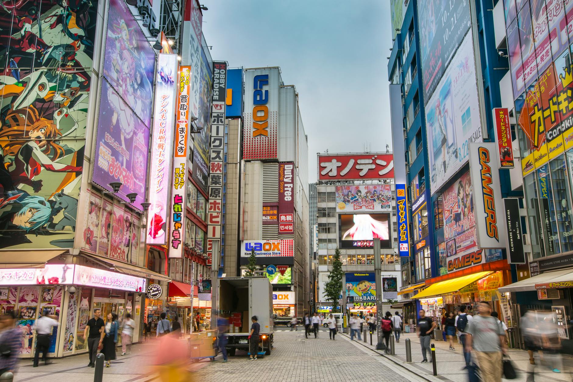 A bustling street in Akihabara, Tokyo filled with bright neon signs and pedestrians.