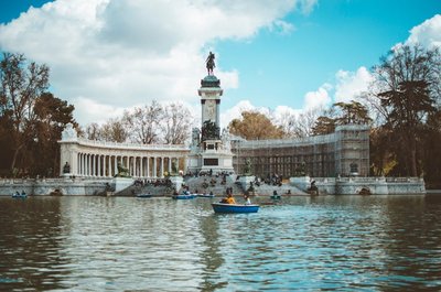 Scenic view of Monument to Alfonso XII, Retiro Park, Madrid, with boating on the lake.