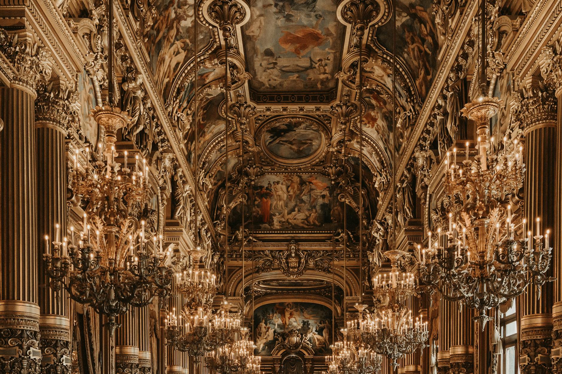 Lavish baroque interior of Palais Garnier showcasing chandeliers and ornate ceilings in Paris.