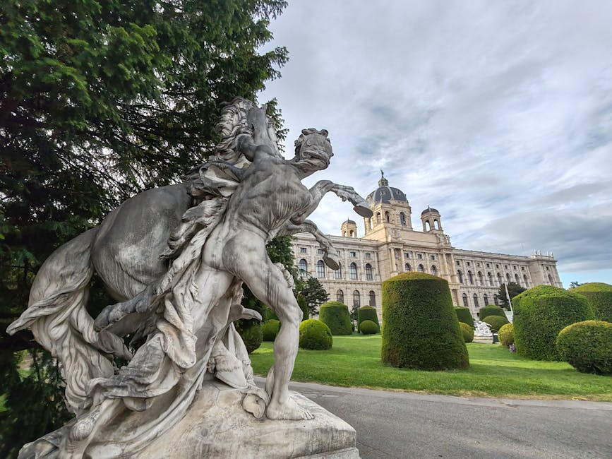 Dramatic sculpture outside Vienna's iconic museum on a cloudy day.