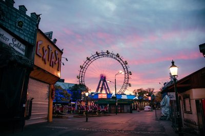 The illuminated Vienna Ferris Wheel at dusk in Prater Park, offering a serene skyline view.