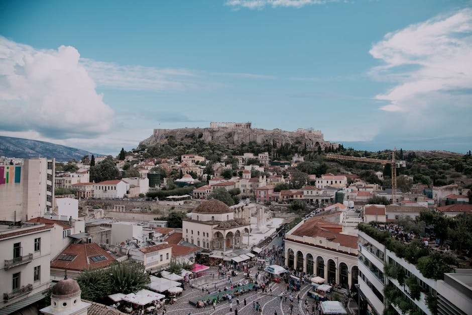 Stunning aerial view of Athens cityscape with iconic Acropolis under blue skies.