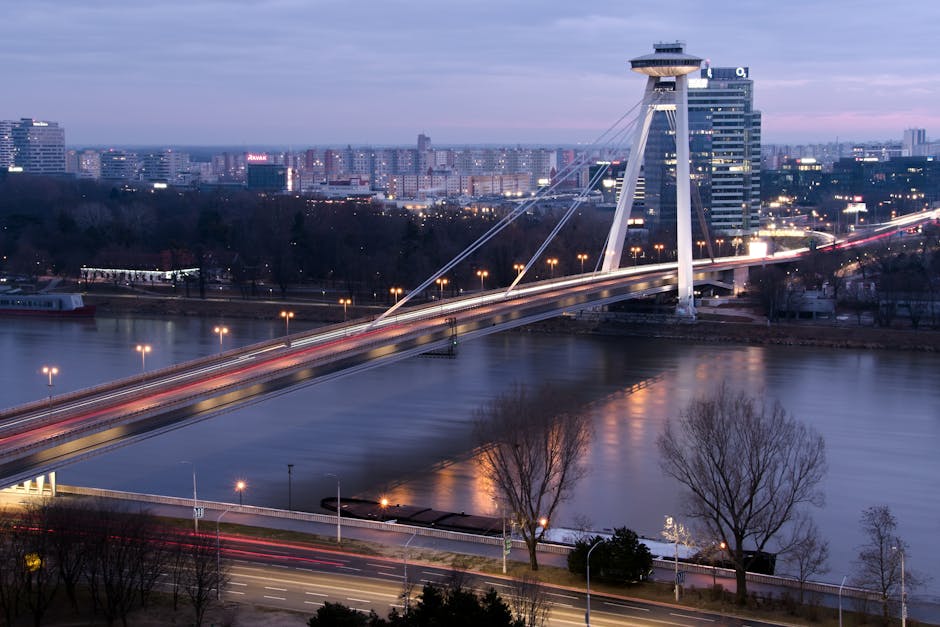 View of the iconic UFO Bridge spanning the Danube River in Bratislava at twilight.