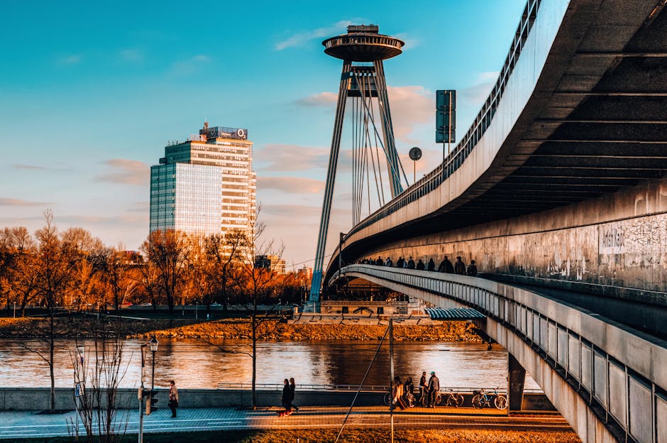 Stunning view of Bratislava's UFO Bridge and cityscape during sunset overlooking the Danube River.