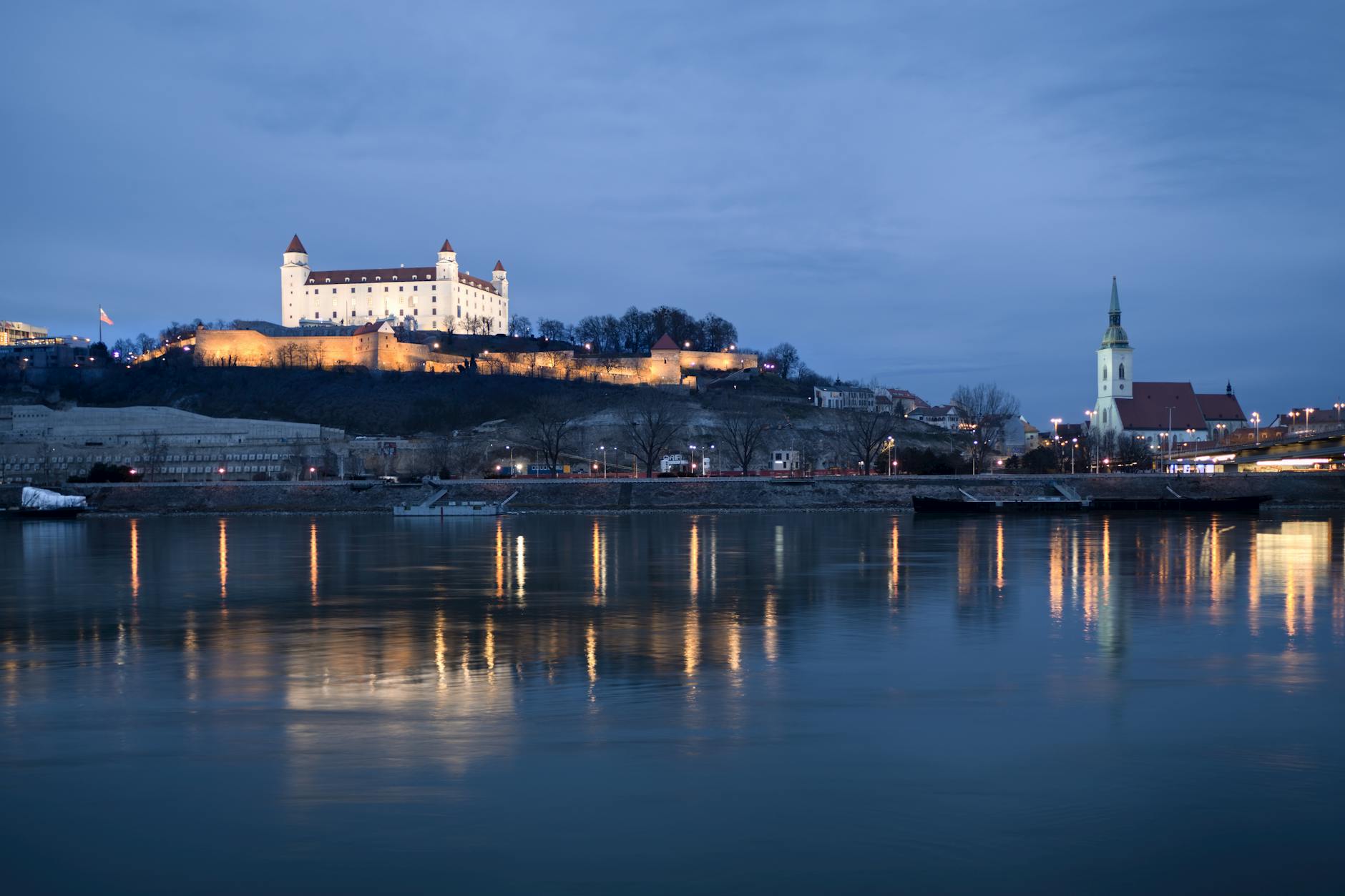 A captivating nighttime view of Bratislava Castle reflected in the Danube River.
