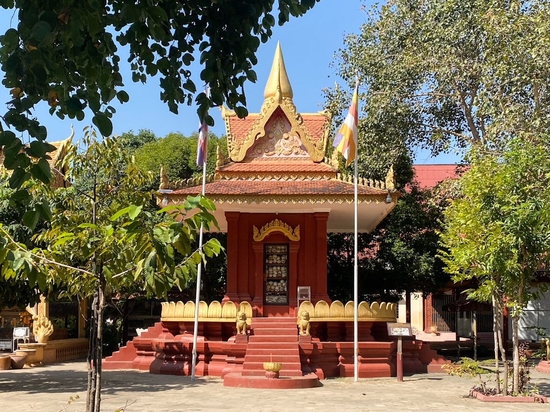 A small red and yellow building sitting in the middle of a park
