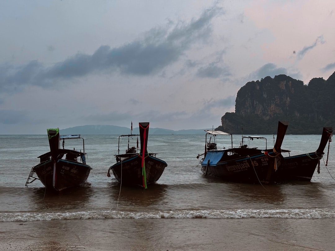 A group of three boats sitting on top of a beach