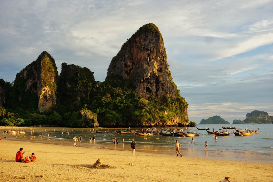 A beautiful beach scene with rock formations and boats.