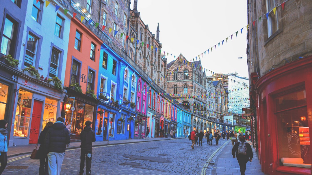 Colorful buildings line a street with people walking.