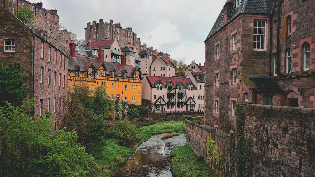 Historic buildings line a stream in a european city.
