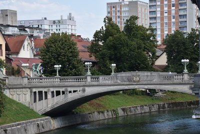 Stone bridge over a river with buildings behind