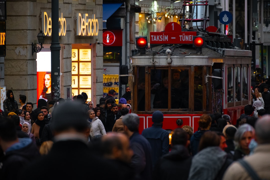 A crowd of people walking down a street next to tall buildings