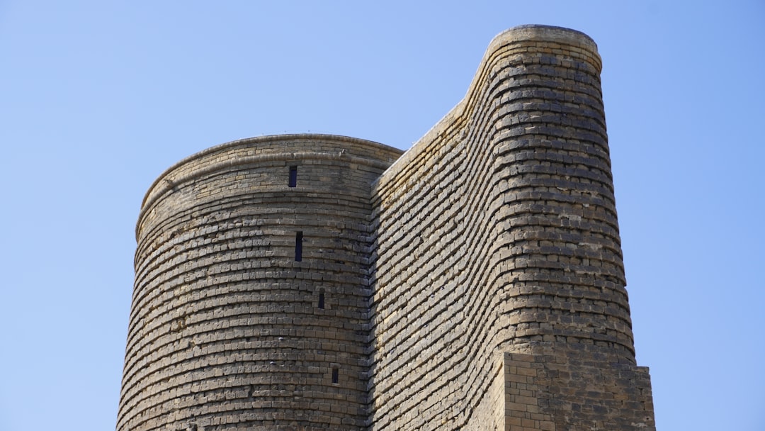 The maiden tower stands tall against a blue sky.