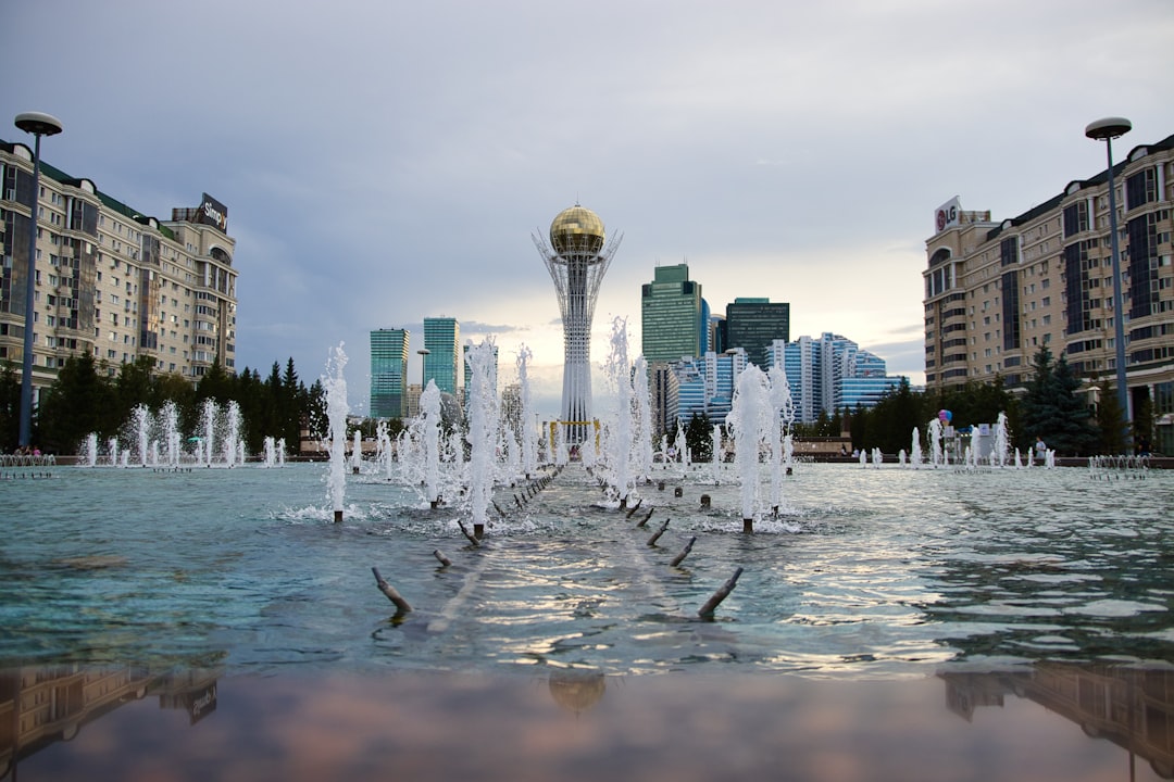 Fountains in a city square with modern buildings